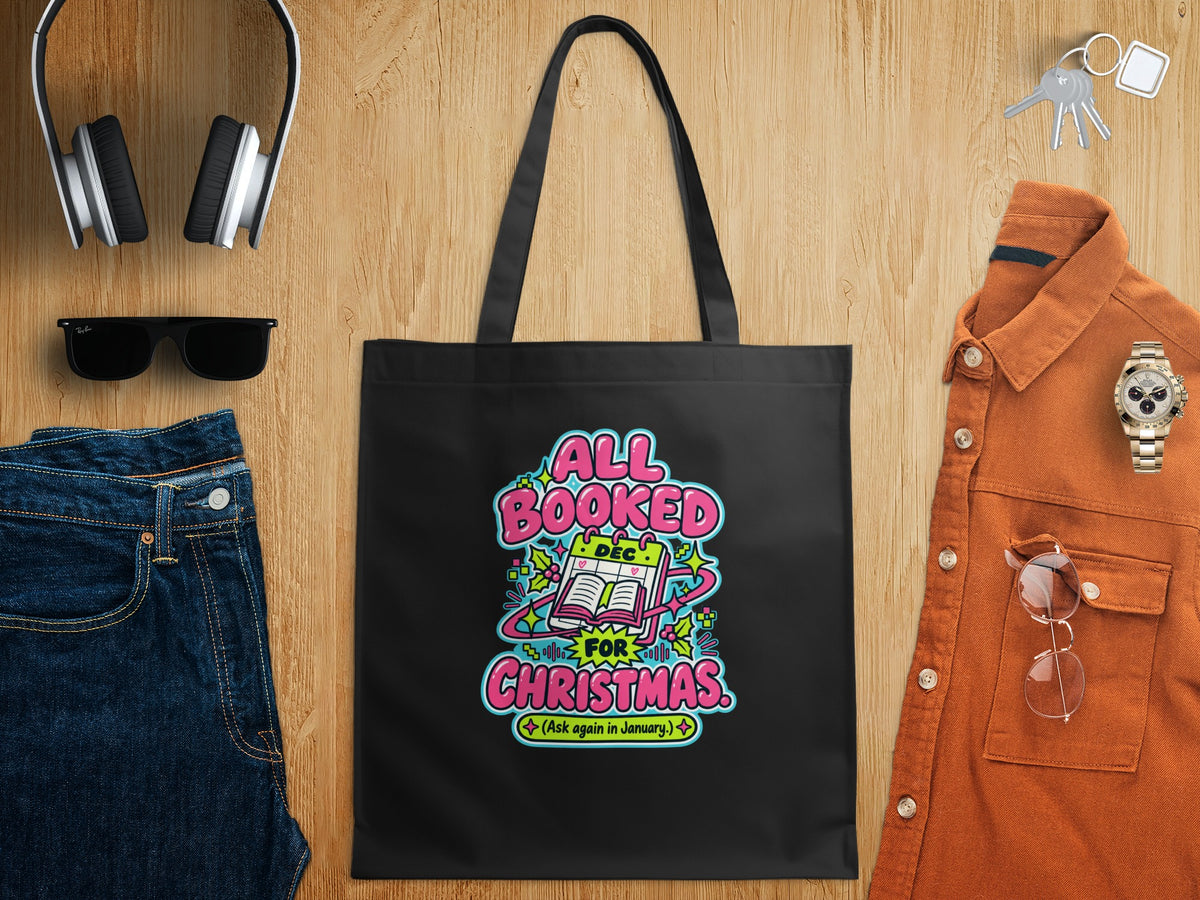 Black tote bag with "All Booked For Christmas" Christmas theme graphic.