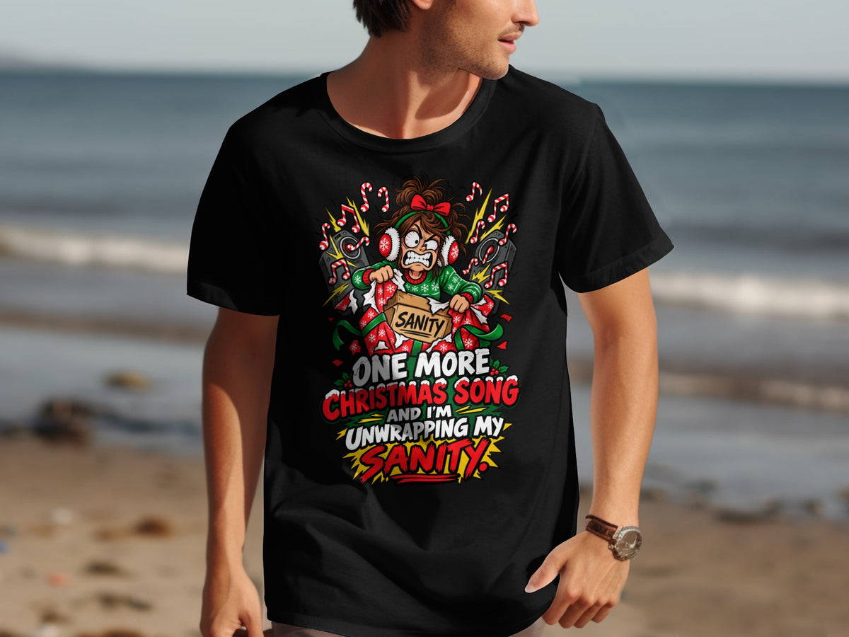 Black t-shirt with cartoon of stressed person unwrapping sanity, text reads "One More Christmas Song and I'm Unwrapping My Sanity."