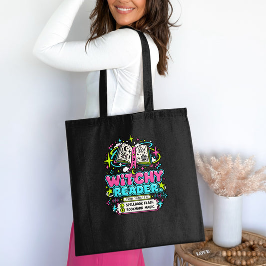 Black tote bag with "Witchy Reader" design including an open book and decorative elements.