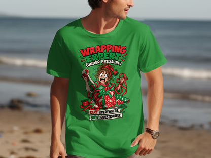 Green t-shirt with a cartoon of a stressed person wrapping a gift, text reads "WRAPPING EXPERT".